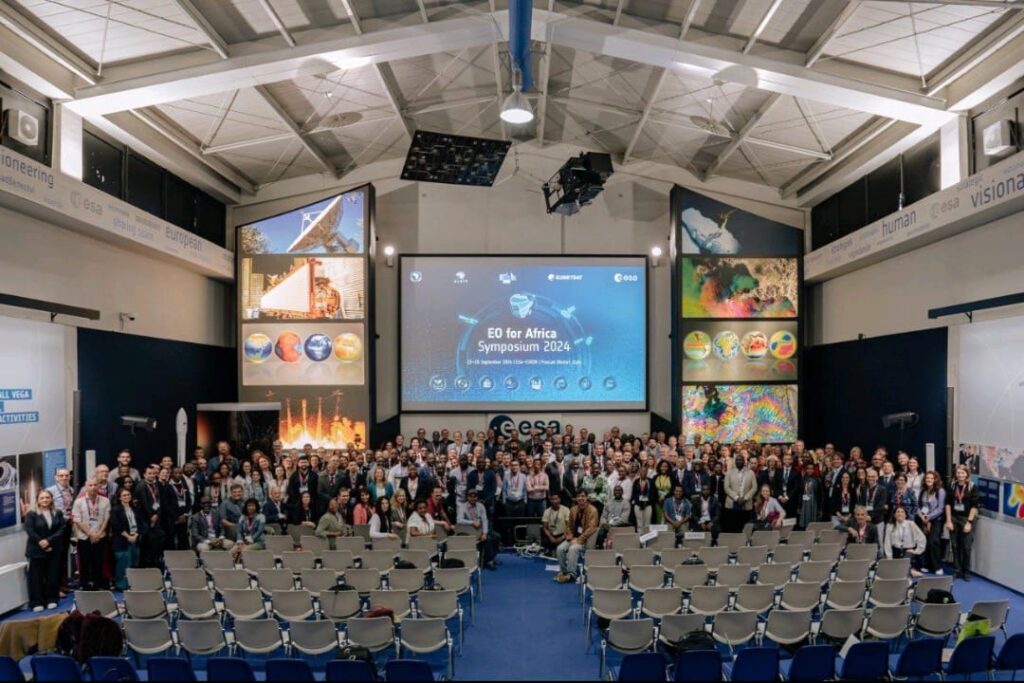 group of 100 persons in a room in front of a slideshow